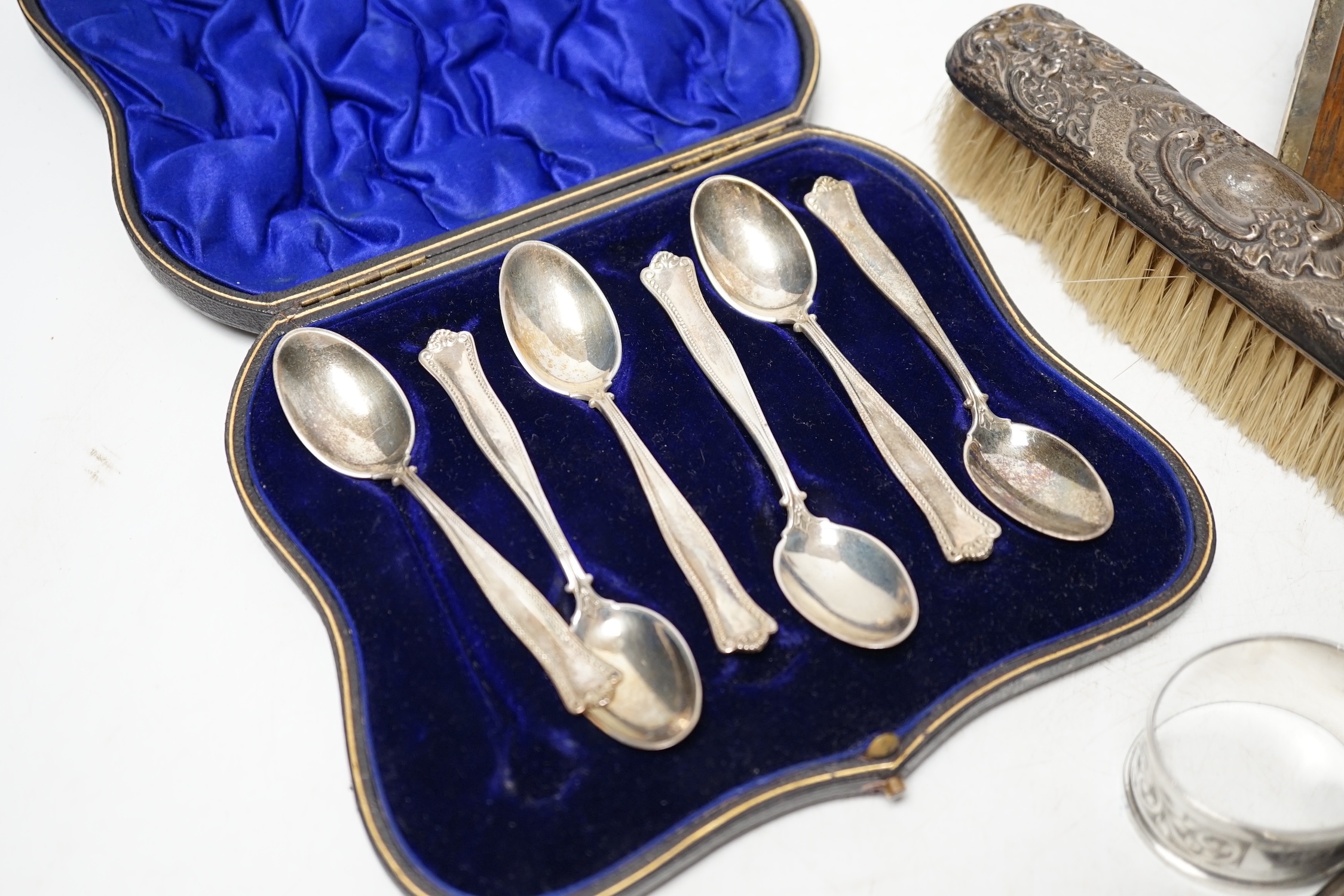 A cased set of six silver teaspoons, a pair of silver pepperettes and four other items including a photograph frame. Condition - poor to fair